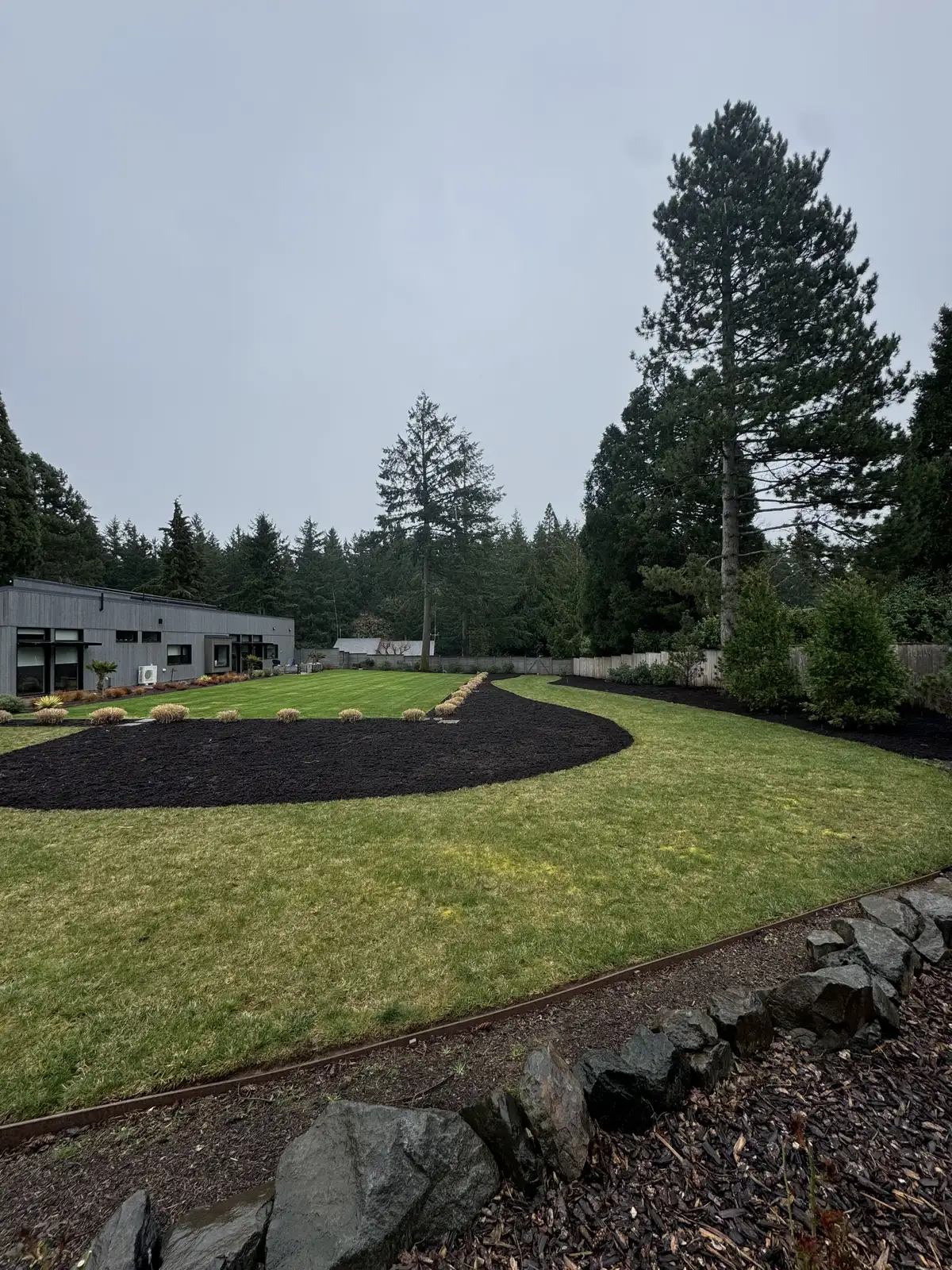Finished landscape bed with stone, plants, and clean edging by CreekView Landscape