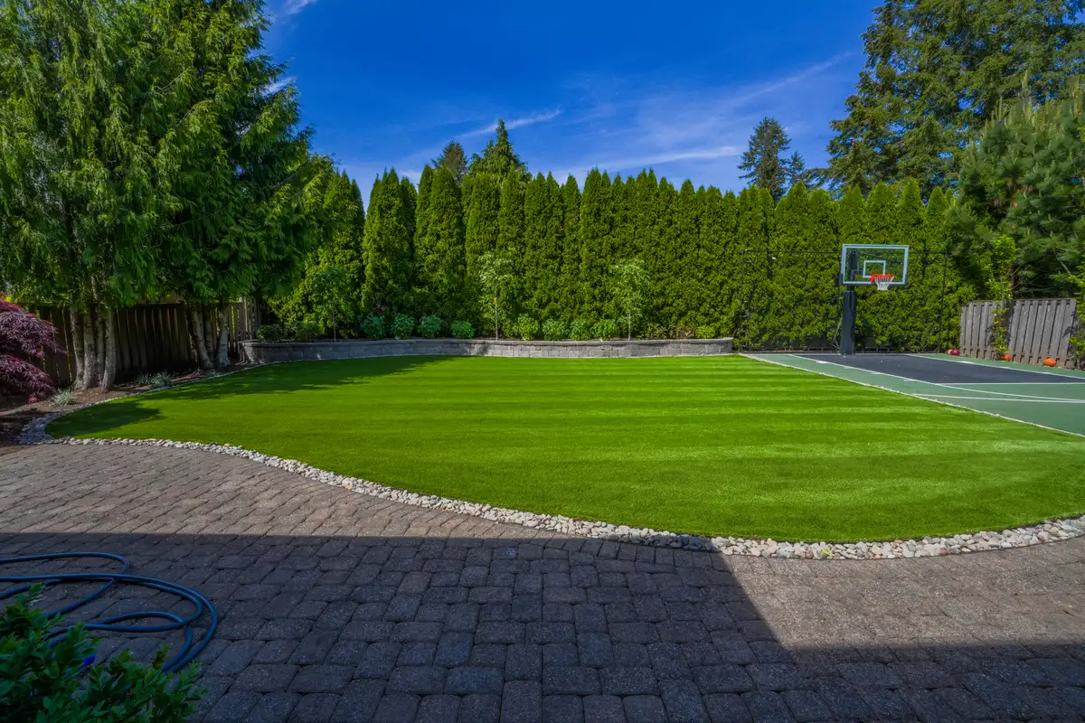 Luxury backyard artificial turf installation with blue sky by CreekView Landscape in Oregon